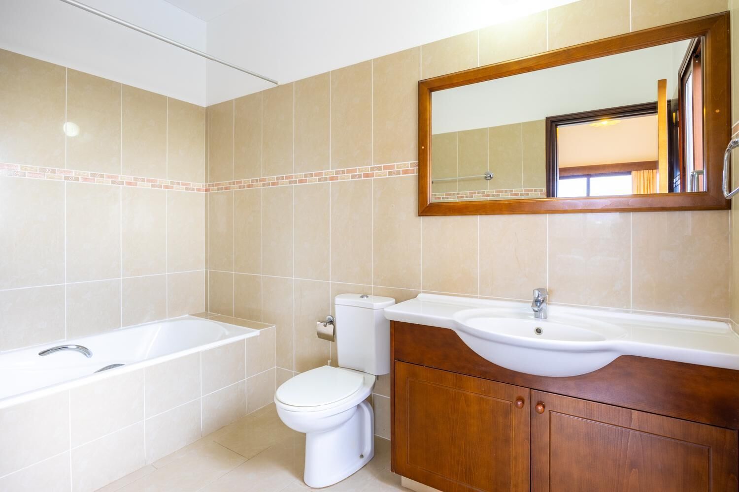 A bathroom with a bathtub, toilet, and vanity with a sink.