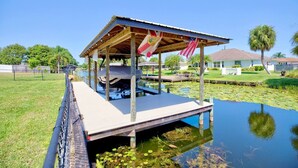 Un muelle techado con bandera estadounidense, rodeado de agua y vegetación.