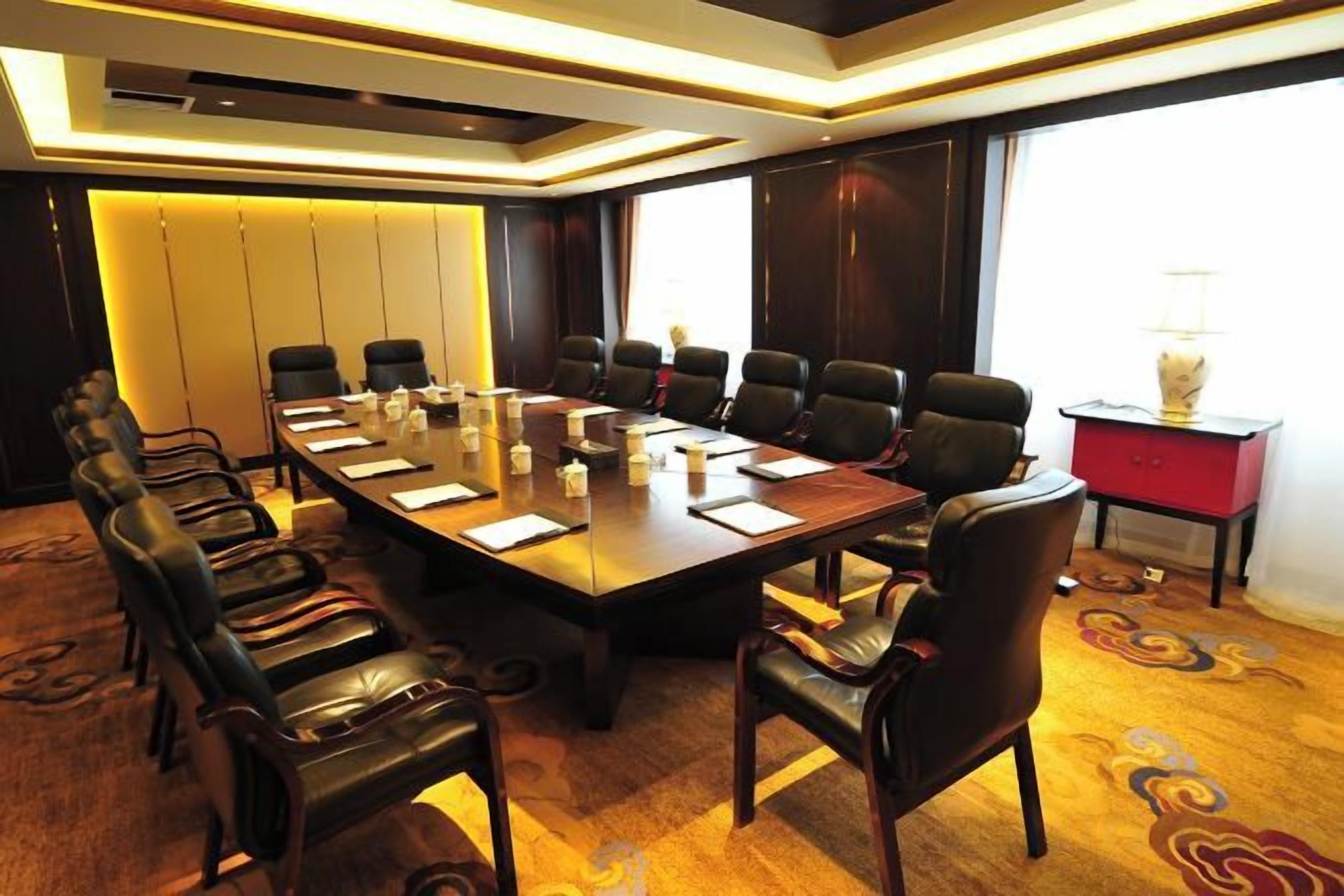 Una sala de conferencias con una larga mesa, varias sillas y un armario rojo.