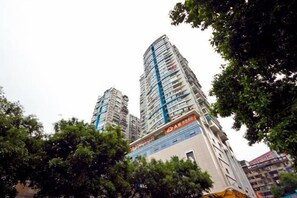 A high-rise building with multiple floors, surrounded by trees.