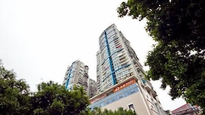 Ein Hochhaus mit mehreren Etagen, umgeben von Bäumen.