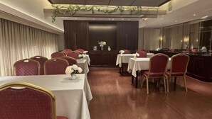Ein Essbereich mit Tischen und Stühlen, eine Bar und eine Rezeption.