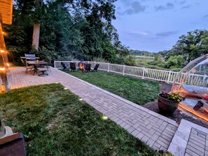 A patio area with a brick pathway, outdoor seating, and a white fence. - Lake retreat with unique dome near Indiana Dunes (Valparaiso)