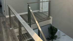 A modern interior with a staircase, a geometric wall decoration, and a contemporary light fixture.