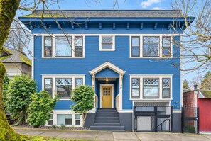 Front of the building: a blue 1910s apartment house with a yellow front door.