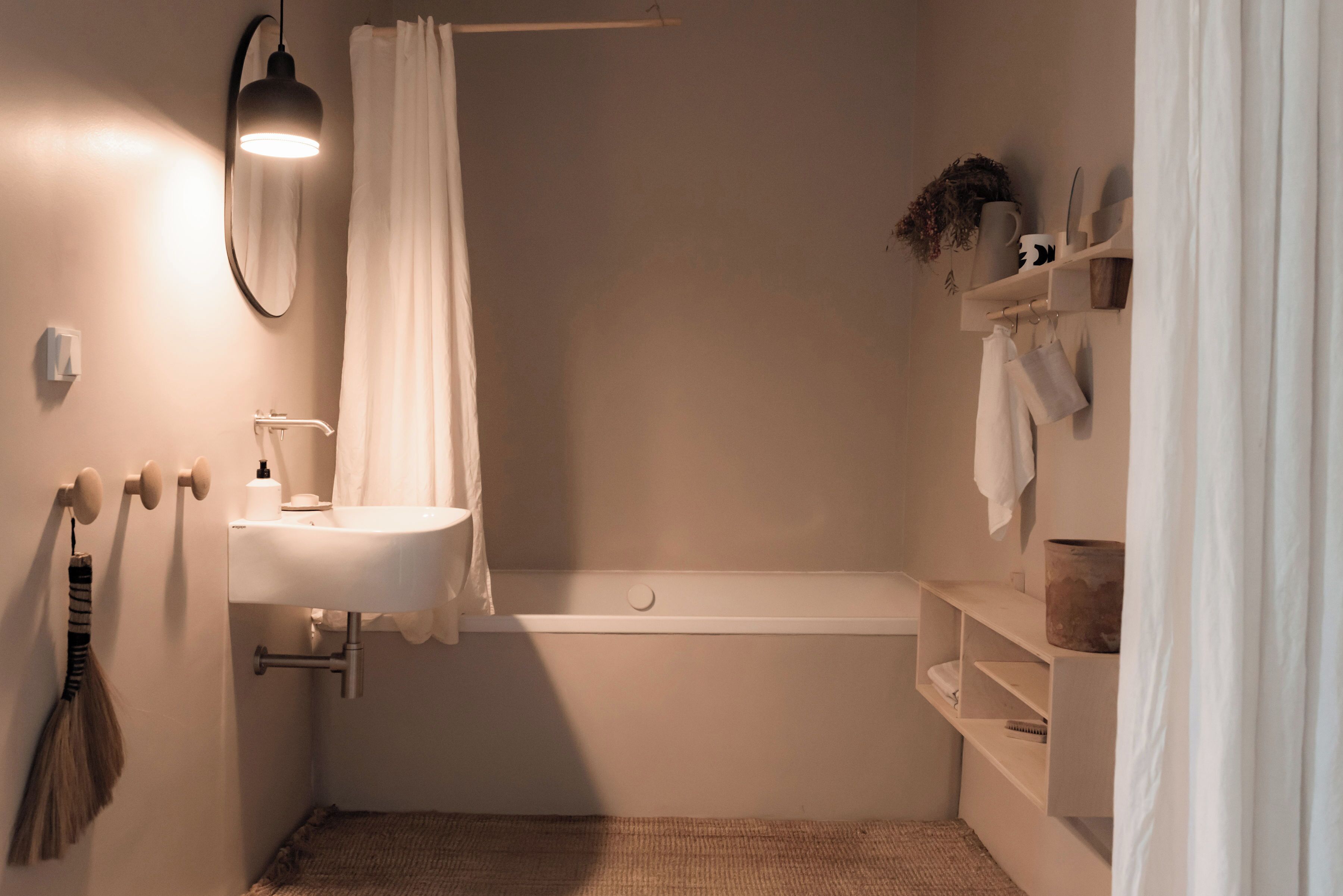 Ein Badezimmer mit einem weißen Waschbecken, einem Spiegel, einer Duschvorhang und einer Badewanne.