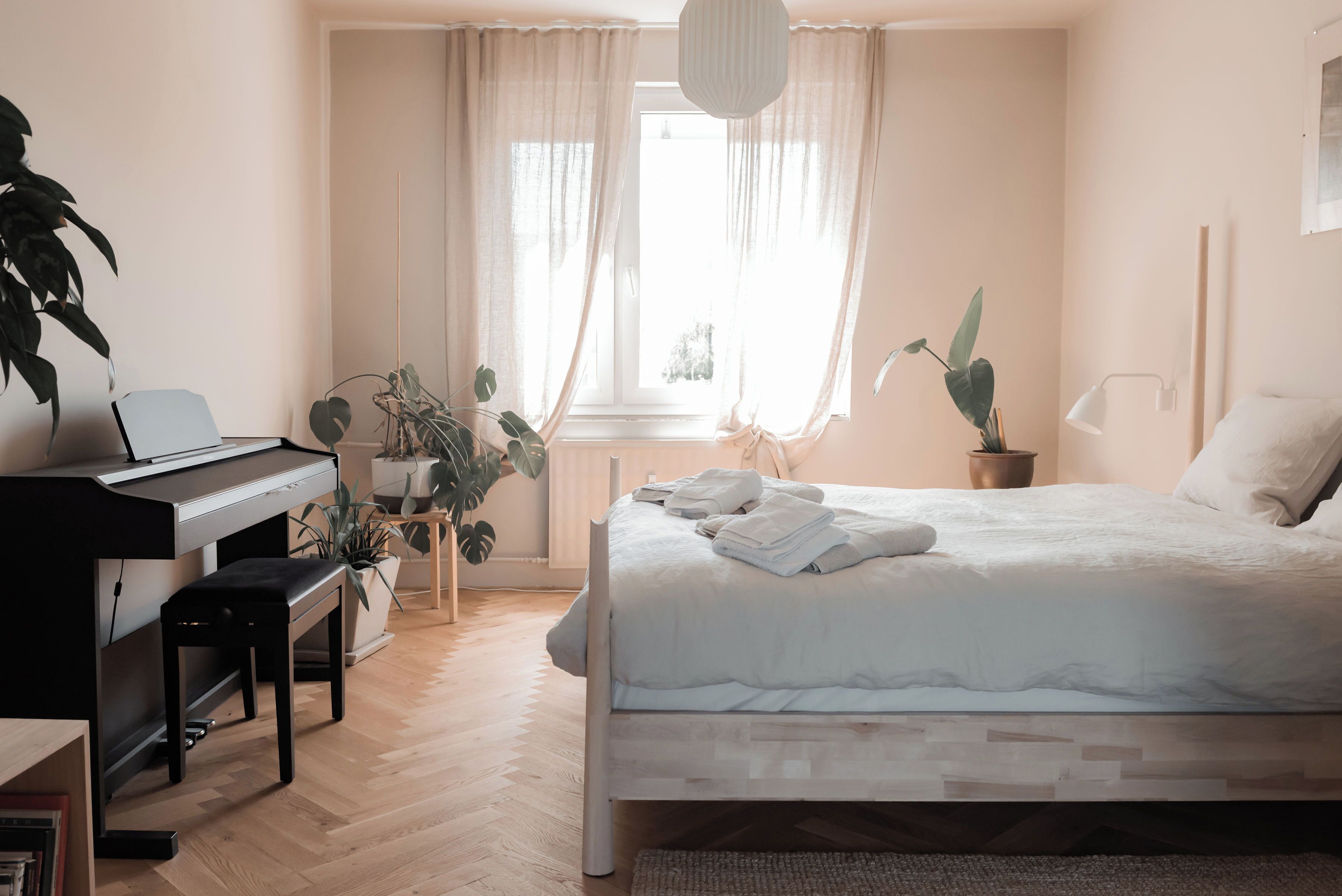 Ein Schlafzimmer mit einem Bett, einem Klavier und Topfpflanzen.