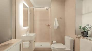 A modern bathroom with a shower, toilet, sink, and vanity.