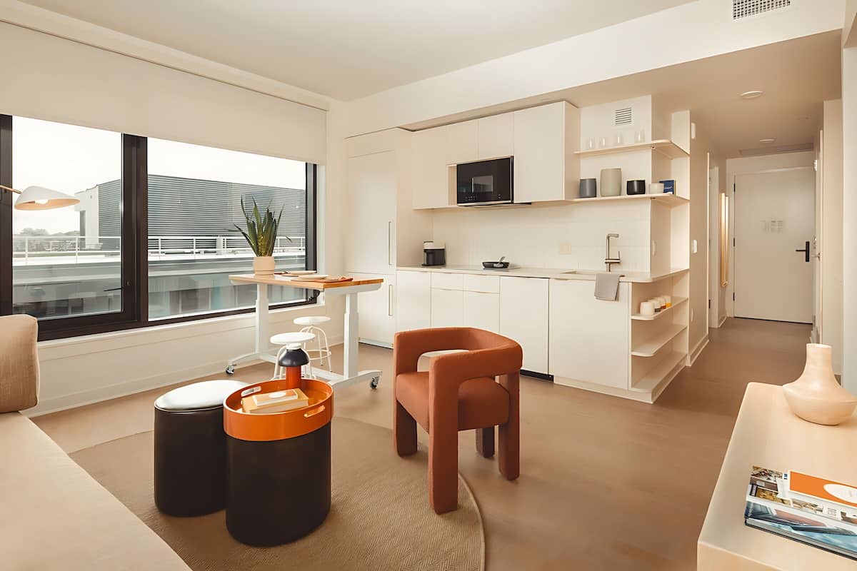 A modern, well-lit living area with a kitchen, a dining table, and a comfortable seating area.