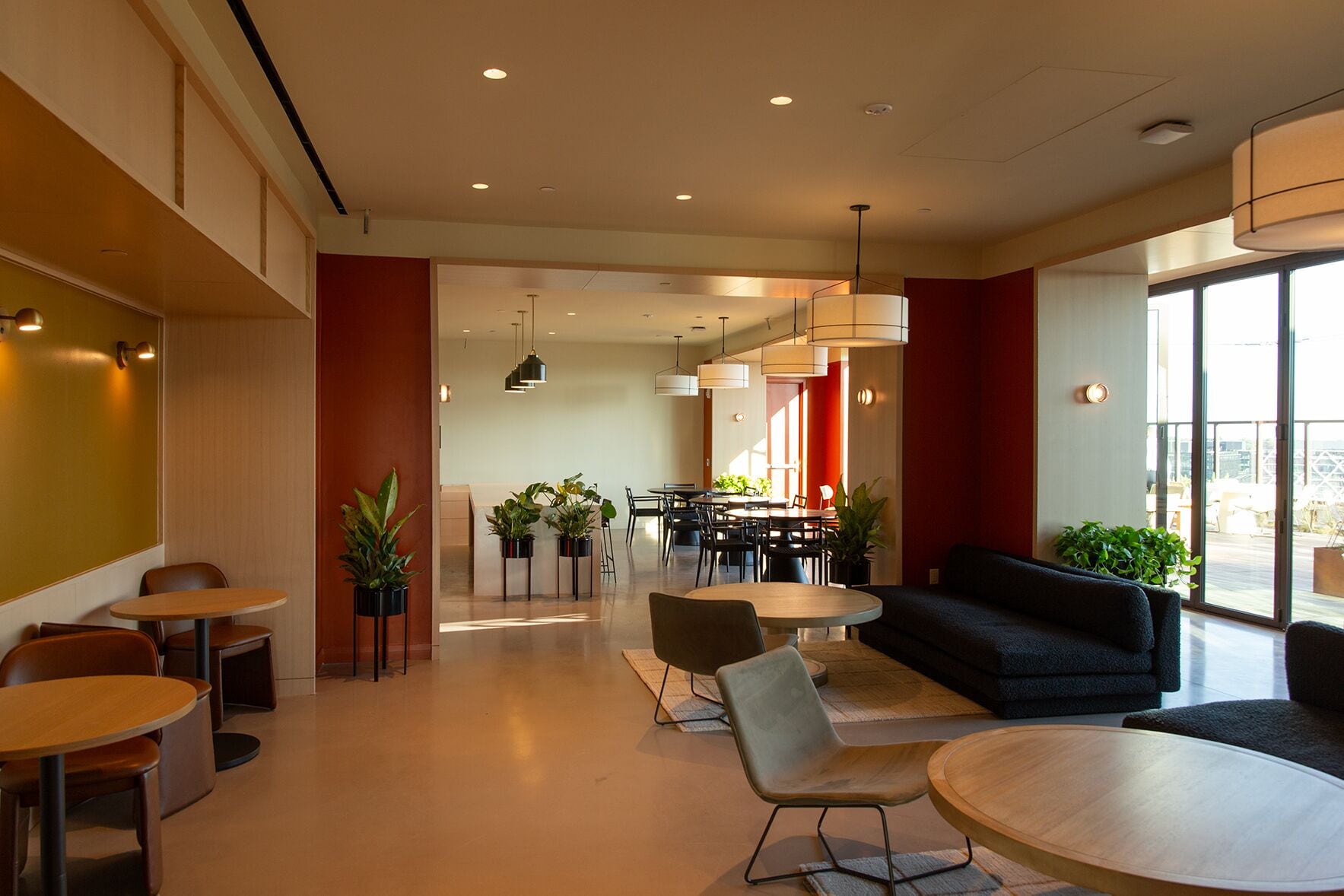A modern interior with a dining area, seating, and plants.