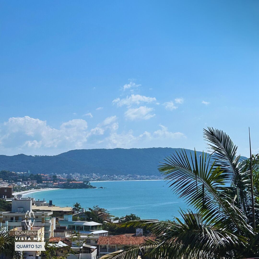 A coastal cityscape with a view of the sea and mountains.