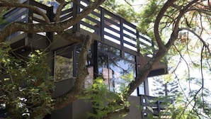 A modern building with large windows and a wooden deck. - Bombinhas Vista Mar (Bombinhas)
