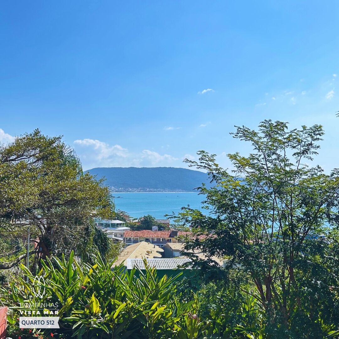 A coastal view with buildings in the foreground and a clear blue sea in the background.