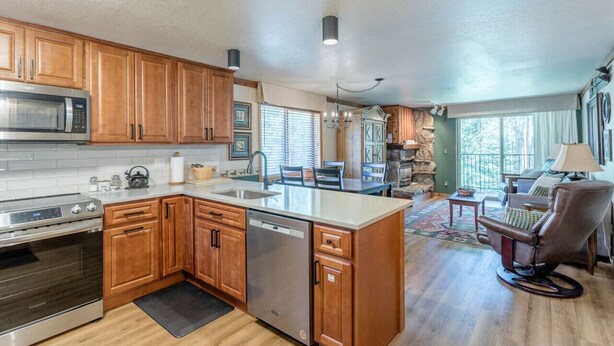 A modern kitchen with wooden cabinets, stainless steel appliances, and a central island.