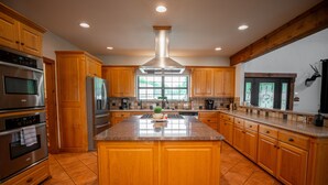 Una cocina amplia con armarios de madera, electrodomésticos de acero inoxidable y una isla grande.