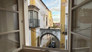 A narrow street with a small bridge and a car parked on the road. - Bombarda 15 Evora (Évora)