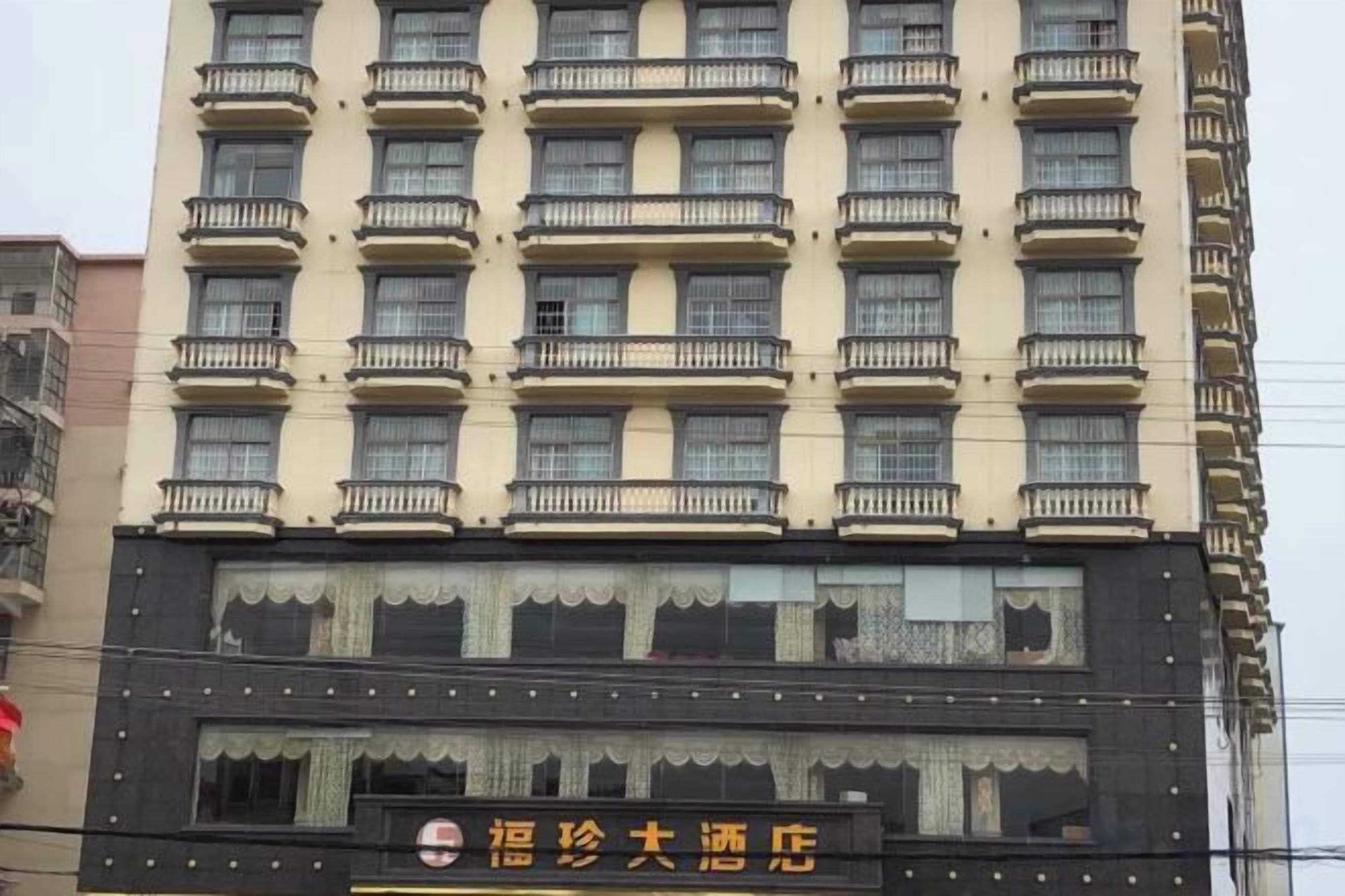 A multi-story hotel building with balconies, a signboard, and a facade with decorative elements.