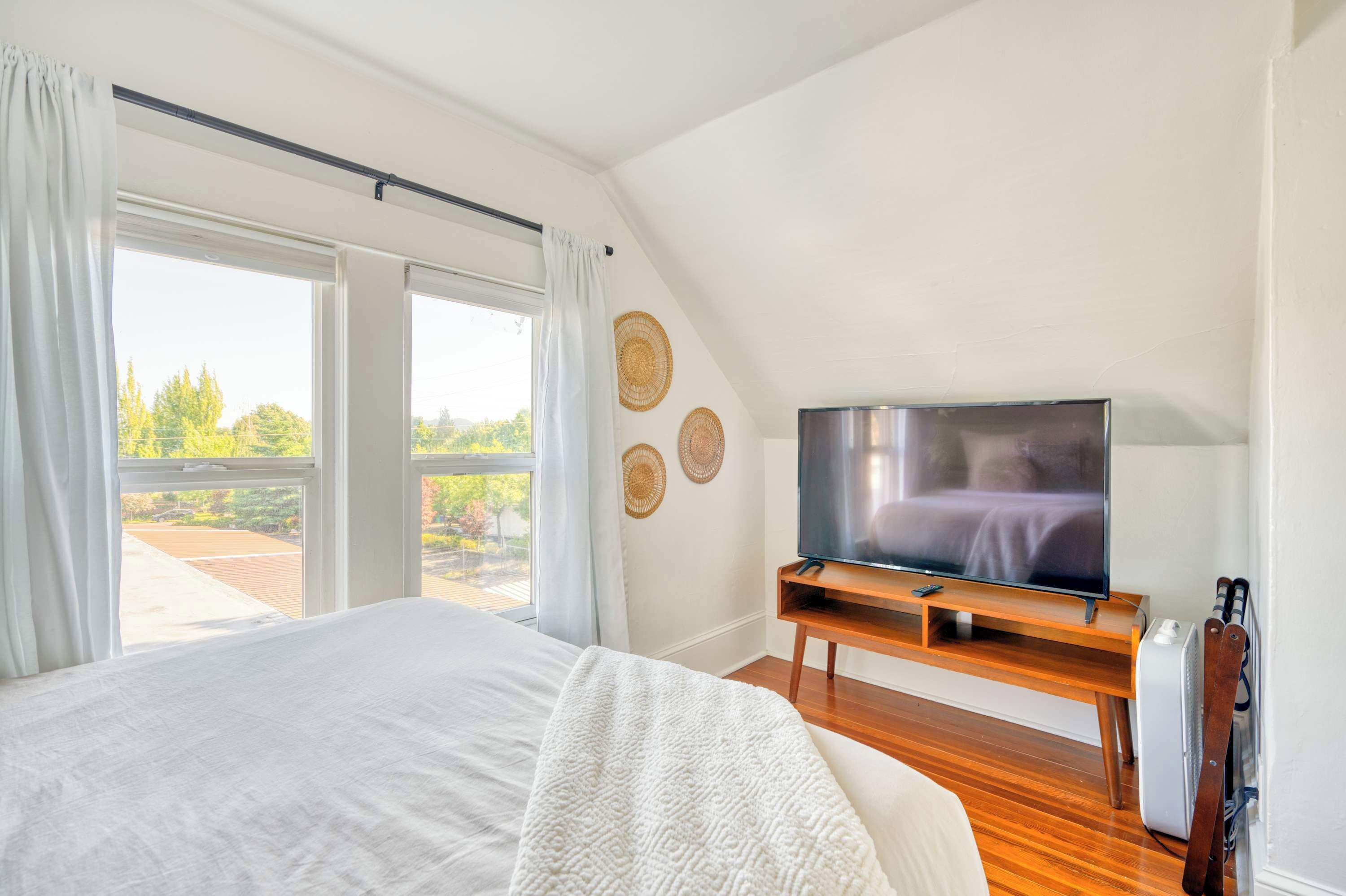 Upstairs bedroom with a bed facing a TV.