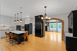 A modern kitchen with a central island, built-in appliances, and pendant lighting.
