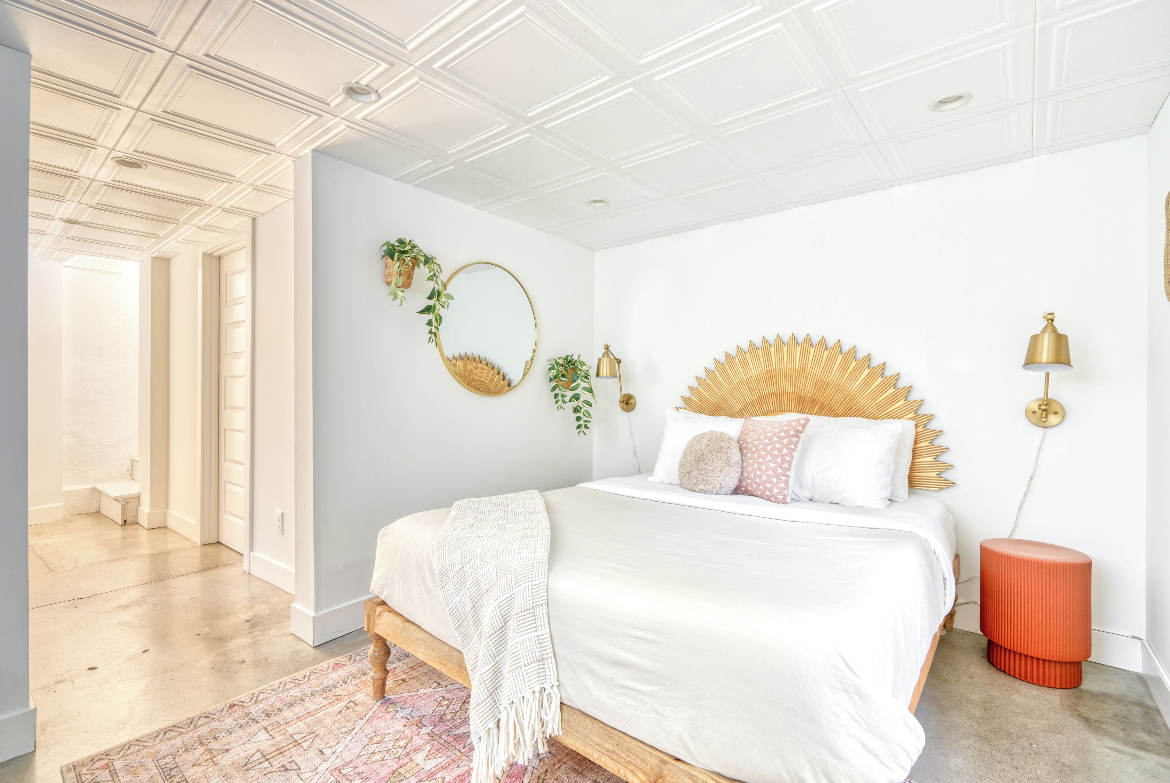 Sleeping area with a decorative wood headboard beside the hall.