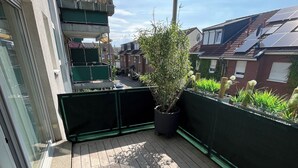 A wooden deck with a potted plant, a welcome mat, and a view of a residential street. - Excellent connections to the trade fair, cathedral and old town by public transport, yet in a very quiet location  (Köln)