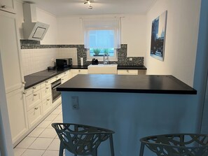 Microondas, placa de cocina, cafetera o tetera y utensilios de cocina