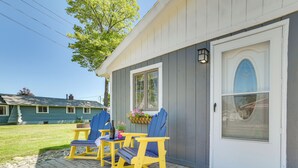 A house with a porch featuring two rocking chairs and a table. - Houghton Lake Cottage w/ Patio: Walk to Waterfront (Houghton Lake)