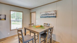 Ruokailutilassa on puinen pöytä, neljä tuolia ja kyltti, jossa lukee ”Lakehouse”.