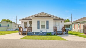 A single-story house with a front porch, a small deck, and a visible garage door. - 1/2 Mi to Ocean: Surfside Beach Resort Home (Myrtle Beach)
