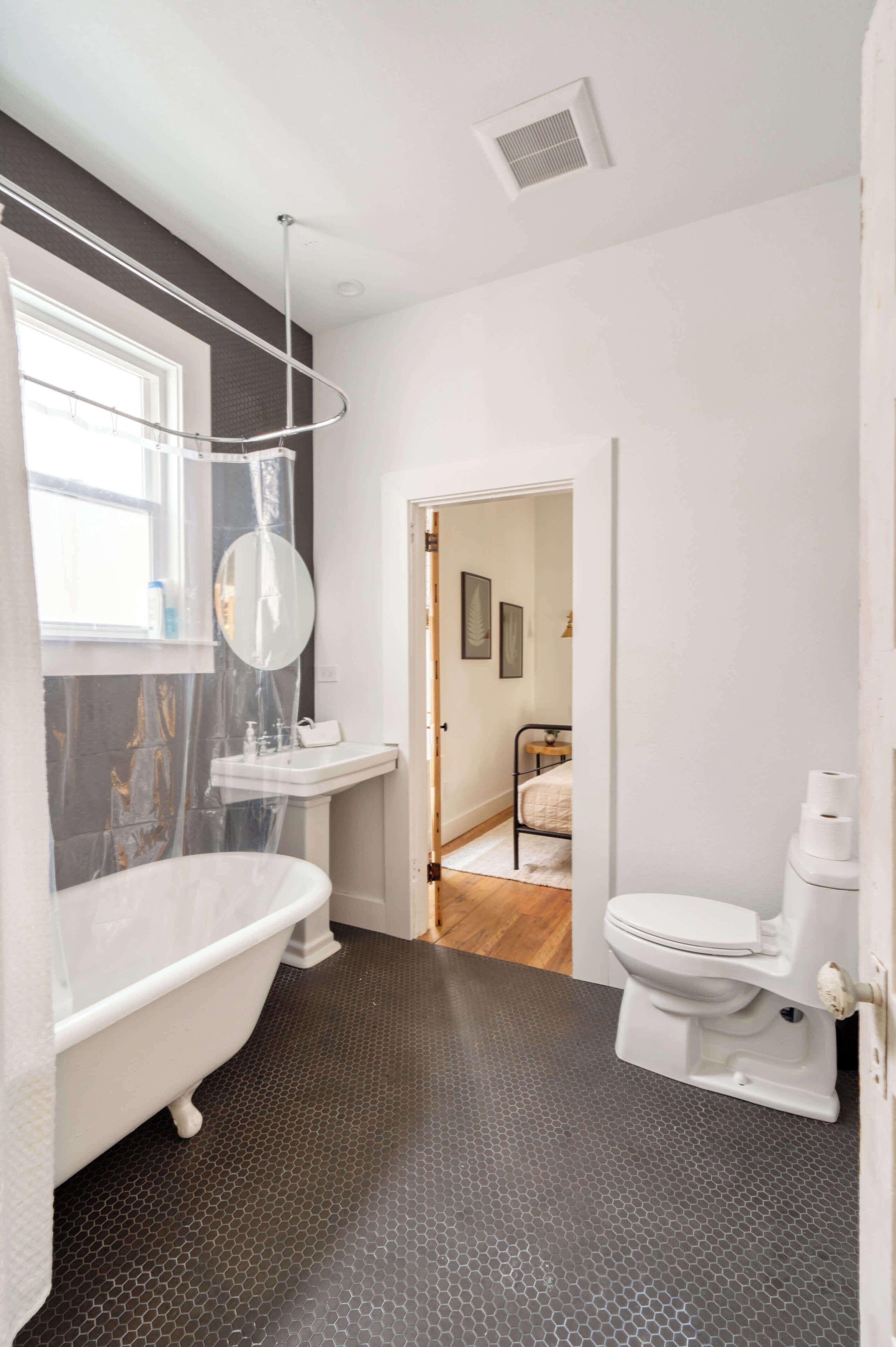A bathroom with a freestanding bathtub, a toilet, and a sink.