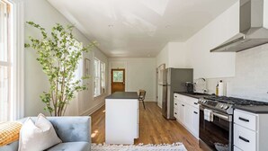 Una cocina moderna con armarios blancos, una isla central y un horno empotrado.