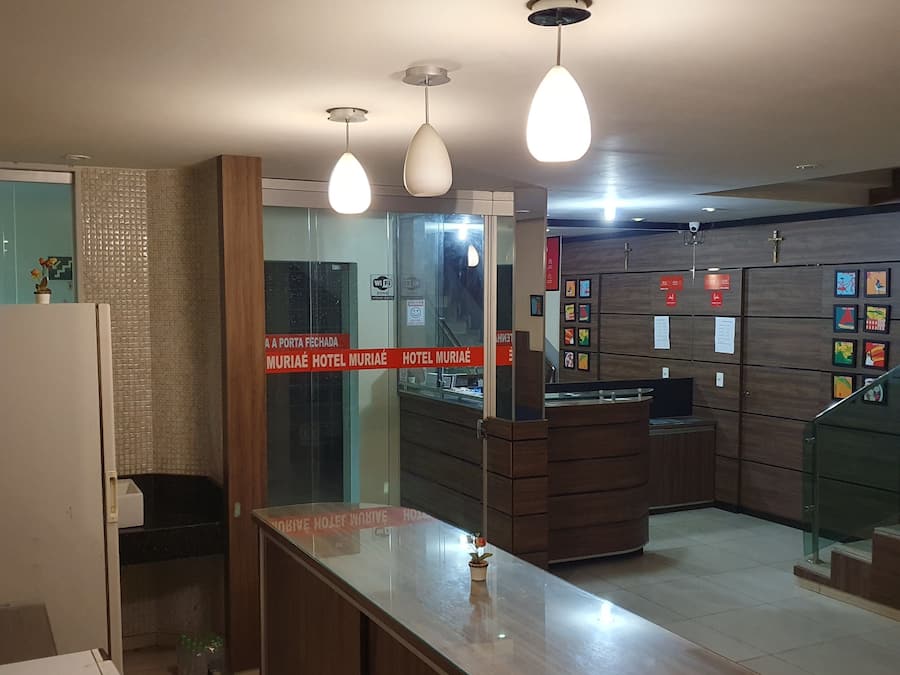 Un espace d’accueil d’hôtel avec un comptoir en bois, des portes en verre et un panneau indiquant la disponibilité du Wi-Fi.