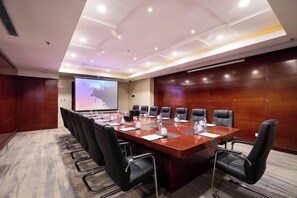 A conference room with a long table, multiple chairs, a projector screen, and a presentation screen. - Ordos Aili Hotel (Beijing Jinbao Street) (Beijing)