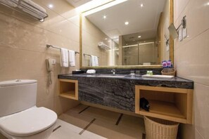 A modern bathroom with a marble sink, a large mirror, a toilet, and a wicker basket. - Ordos Aili Hotel (Beijing Jinbao Street) (Beijing)