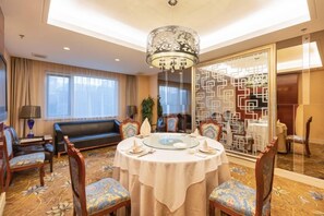 A hotel room with a round dining table, chairs, a sofa, and a chandelier. - Ordos Aili Hotel (Beijing Jinbao Street) (Beijing)