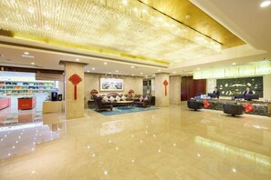A hotel lobby with a reception desk, seating area, and a food counter. - Ordos Aili Hotel (Beijing Jinbao Street) (Beijing)