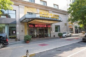 Un hotel con fachada moderna, una entrada destacada y un cartel que indica un precio de 8 unidades.