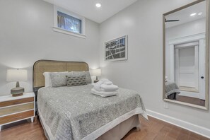 Une chambre à coucher avec un lit, des lampes de chevet, un miroir et une fenêtre.