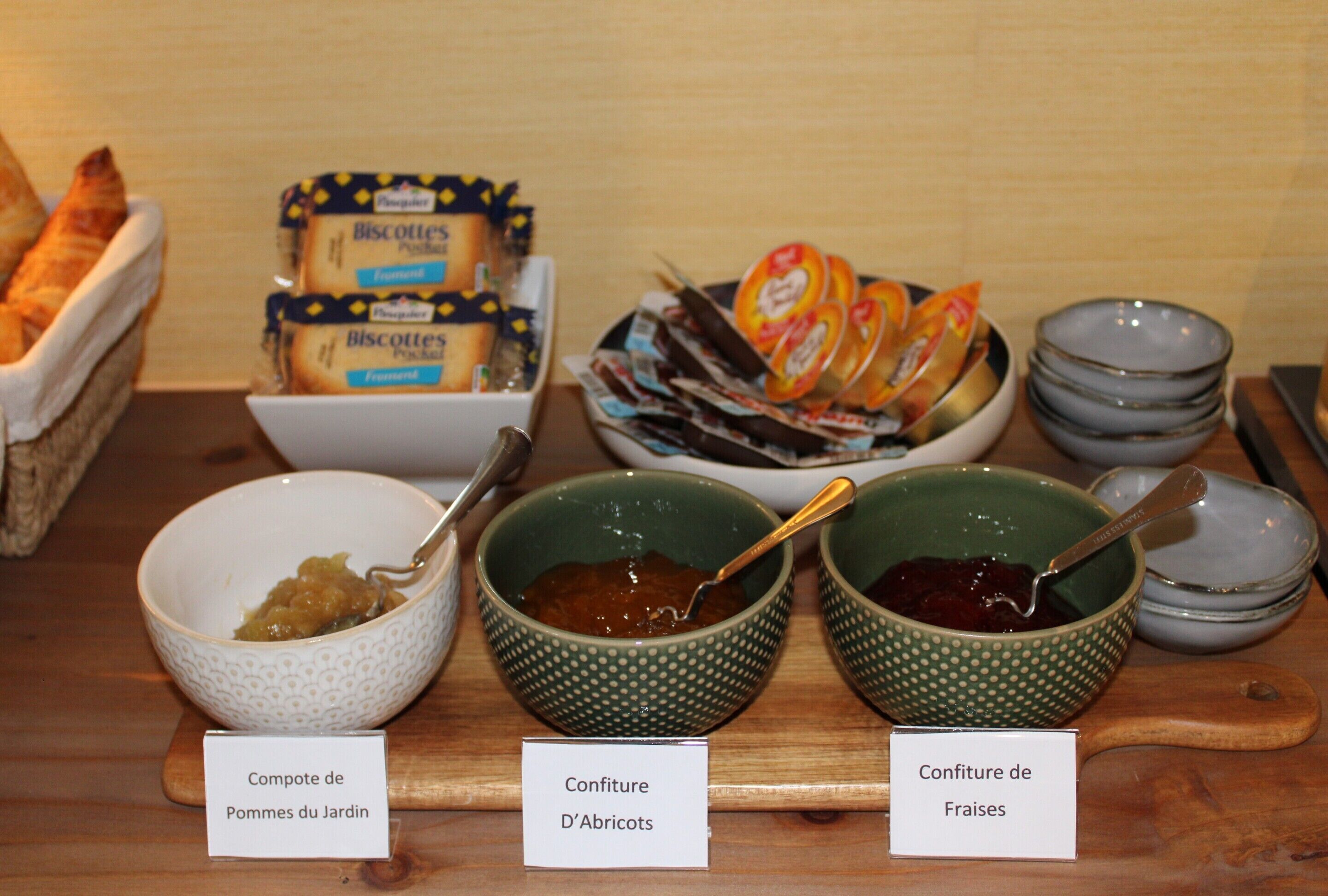 Exposição de comida com potes rotulados de geleias e doces.