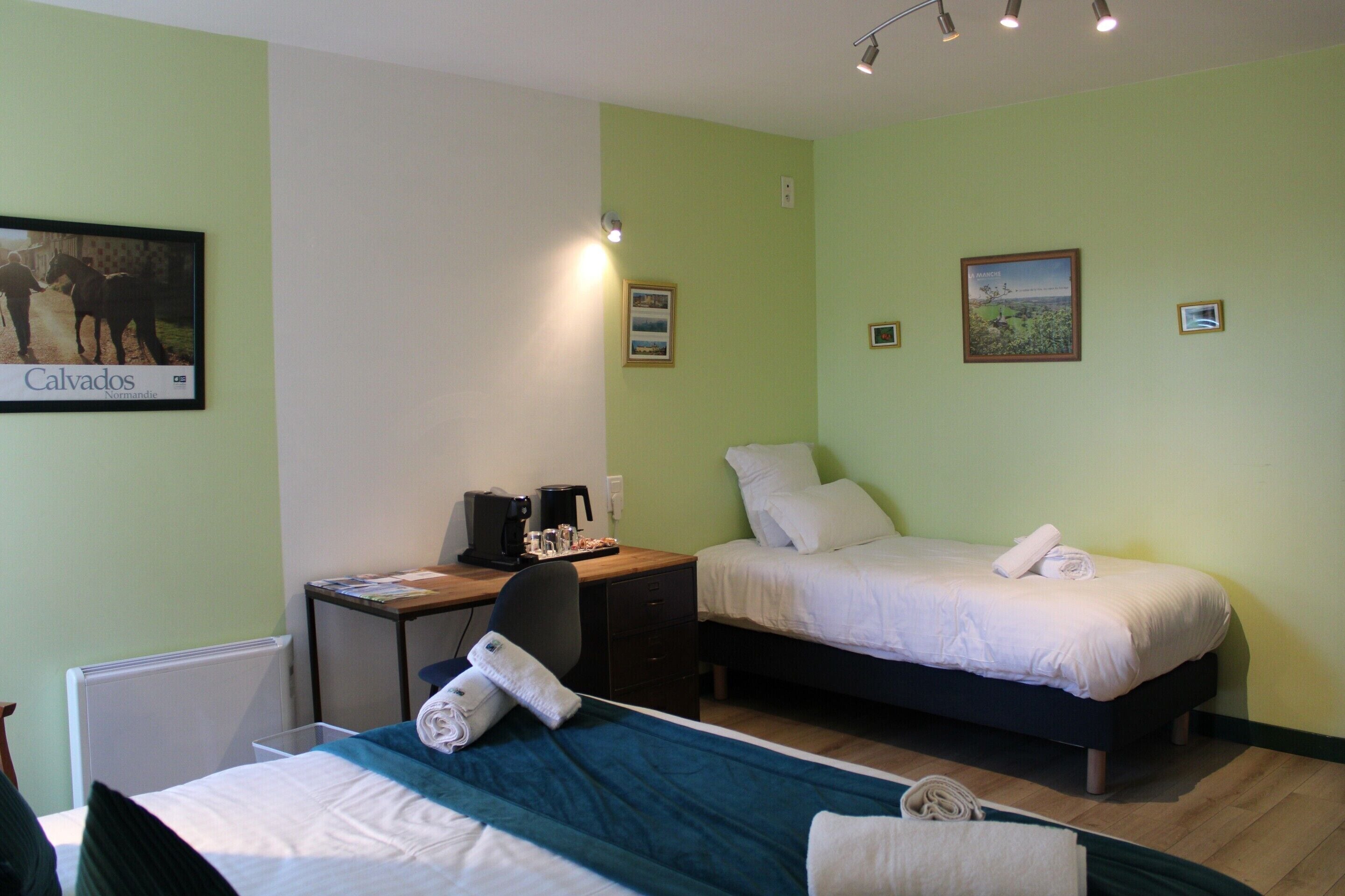 Une chambre avec deux lits, un bureau et une chaise.