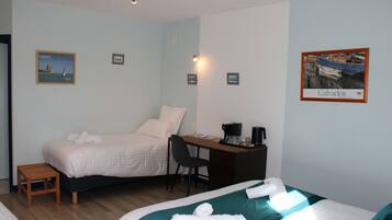 A hotel room with two beds, a desk, a chair, and a small table.