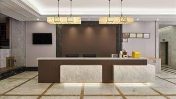 A reception area with a marble counter, a flat-screen TV, and a modern chandelier.