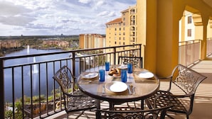 Ein Balkon mit Tisch für zwei Personen, Blick auf einen Fluss und die Stadtlandschaft.