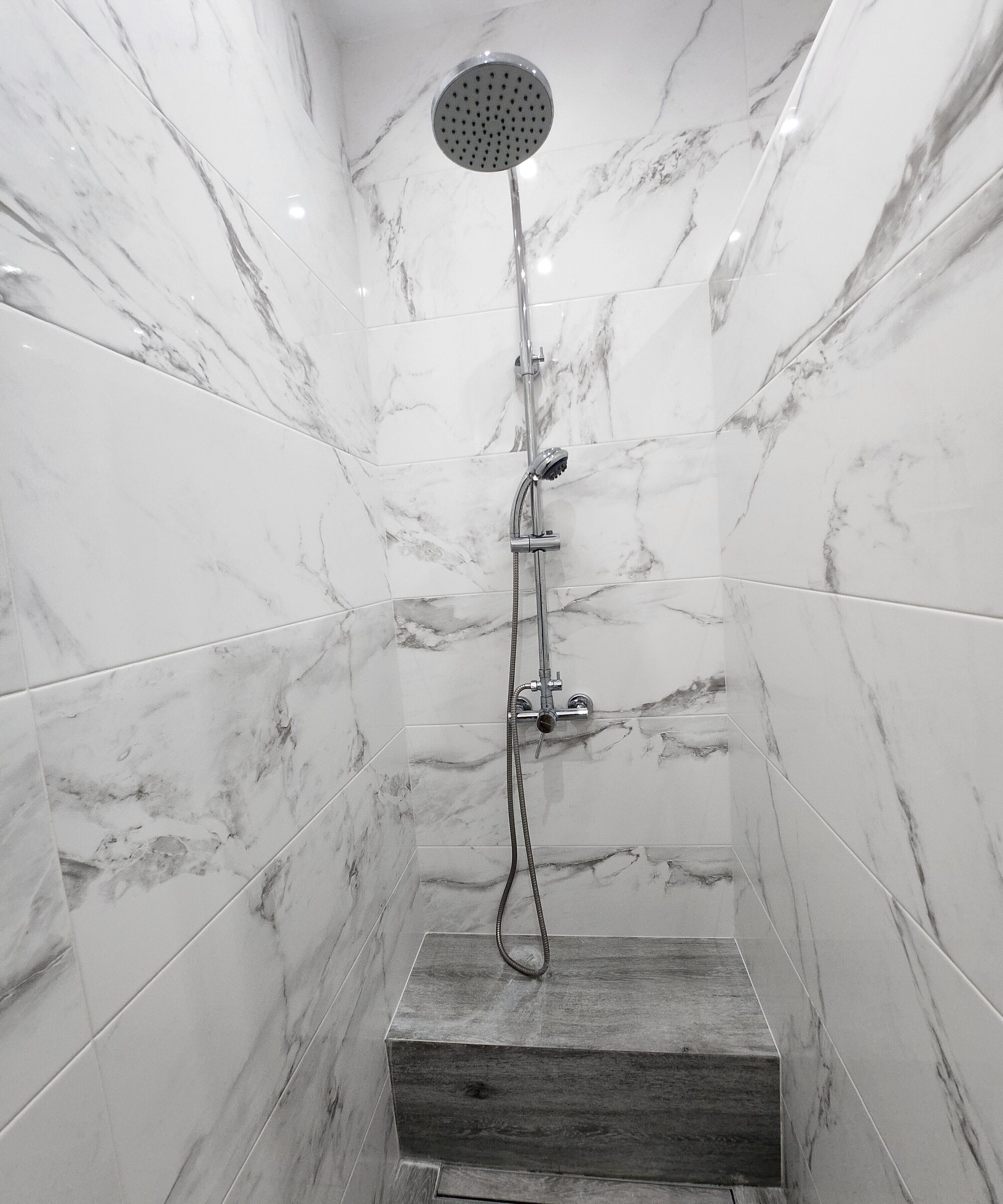 Eine moderne Dusche mit Regendusche, Handbrause und Duschzubehör.
