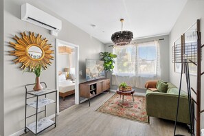 A modern living room with a sofa, TV, and decorative items.
