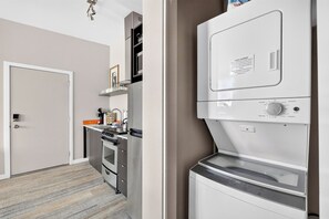 In-unit stacked washer and dryer beside the kitchen. - Stylish Hawthorne 1BR w 90 WalkScore (Portland)
