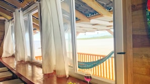 Un mostrador de madera con vista a una playa y una hamaca.