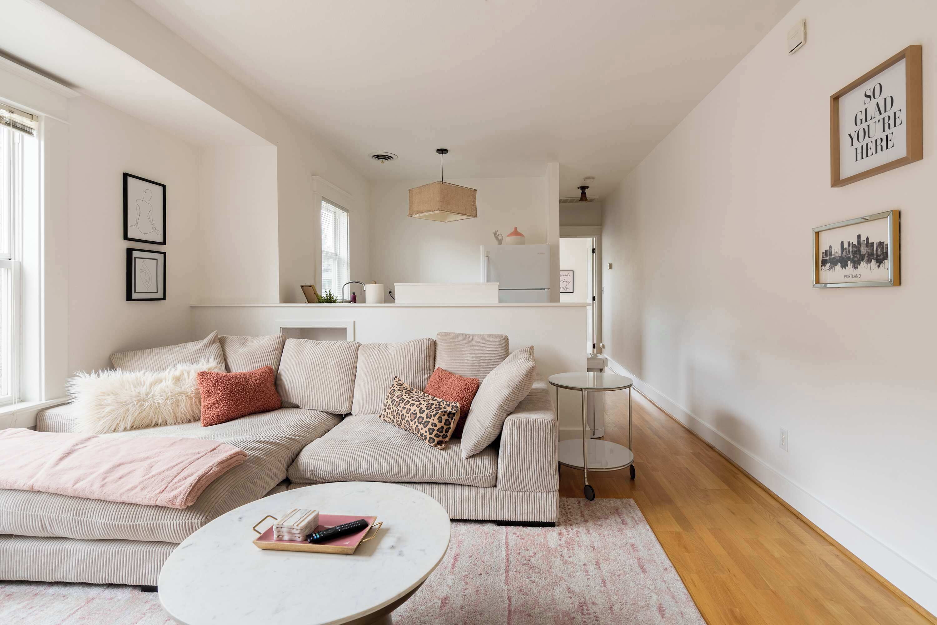 A modern living room with a sectional sofa, a round coffee table, and a small side table.
