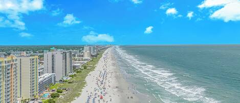 Rannalla, aurinkotuoleja, rantapyyhkeitä