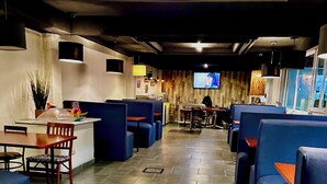 Ein Restaurant mit blauen Sitzbänken, einer Holztresore und einem Fliesenboden.
